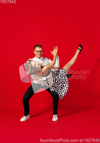 Image of Old-school fashioned young couple dancing isolated on red background