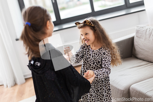 Image of girls in halloween costumes dancing at home