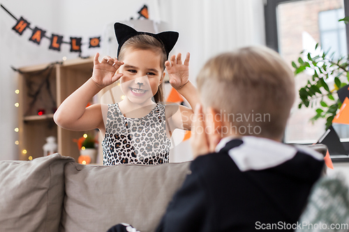 Image of kids in halloween costumes playing at home