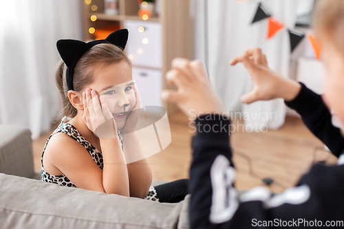 Image of kids in halloween costumes playing at home