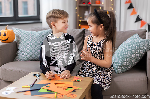 Image of kids in halloween costumes doing crafts at home