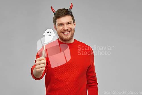 Image of happy man in halloween costume of devil over grey