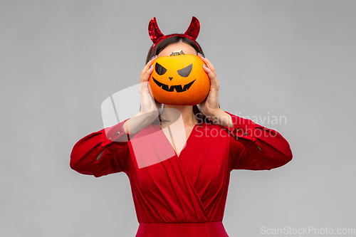 Image of woman in halloween costume of devil with pumpkin