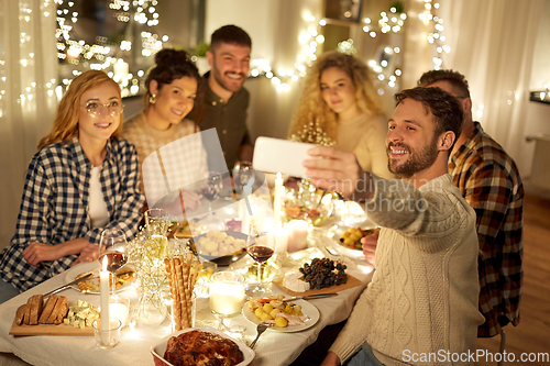 Image of friends taking selfie at christmas dinner party