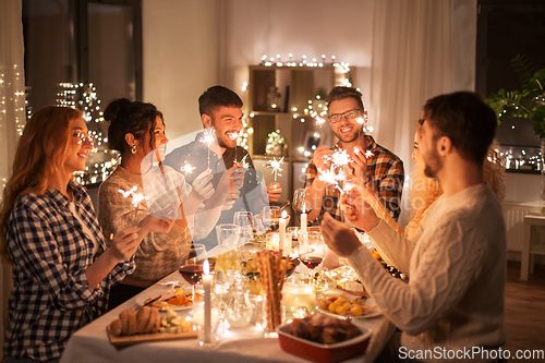 Image of happy friends having christmas dinner at home