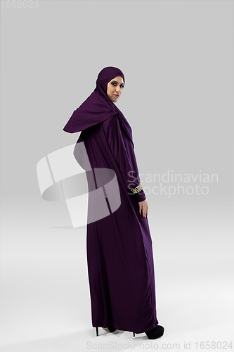 Image of Beautiful arab woman posing in stylish hijab isolated on studio background. Fashion concept