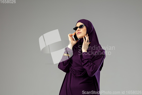 Image of Beautiful arab woman posing in stylish hijab isolated on studio background. Fashion concept