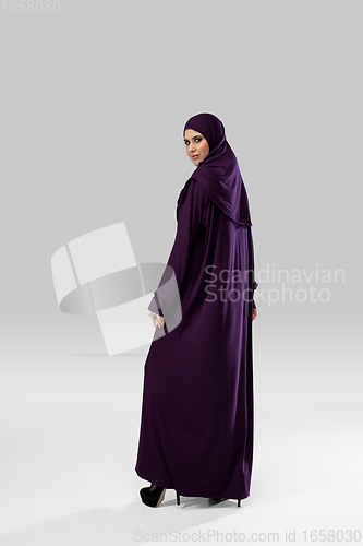Image of Beautiful arab woman posing in stylish hijab isolated on studio background. Fashion concept