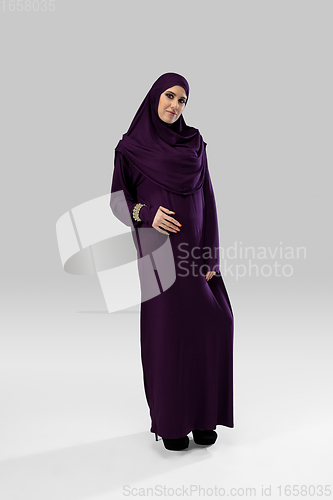 Image of Beautiful arab woman posing in stylish hijab isolated on studio background. Fashion concept