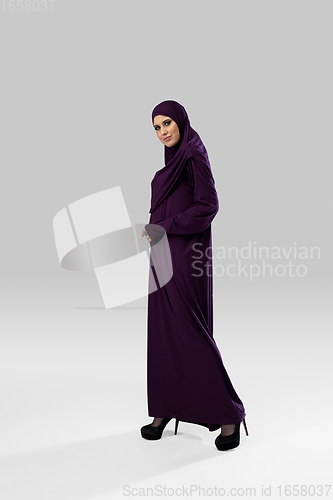 Image of Beautiful arab woman posing in stylish hijab isolated on studio background. Fashion concept