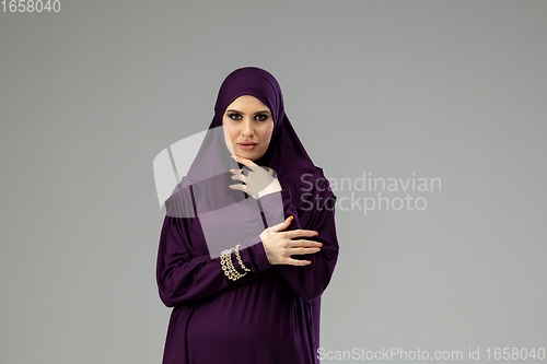 Image of Beautiful arab woman posing in stylish hijab isolated on studio background. Fashion concept