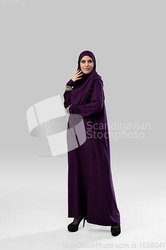 Image of Beautiful arab woman posing in stylish hijab isolated on studio background. Fashion concept