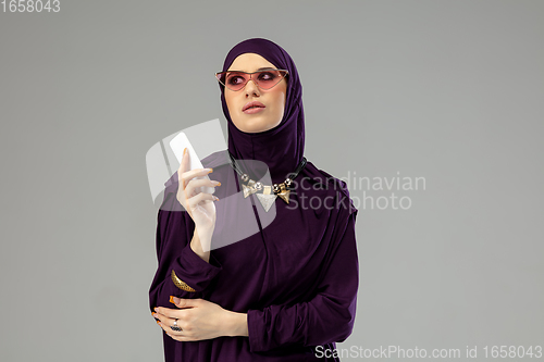 Image of Beautiful arab woman posing in stylish hijab isolated on studio background. Fashion concept