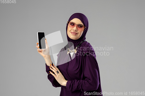 Image of Beautiful arab woman posing in stylish hijab isolated on studio background. Fashion concept