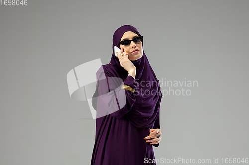 Image of Beautiful arab woman posing in stylish hijab isolated on studio background. Fashion concept