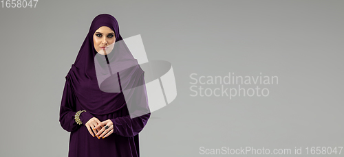 Image of Beautiful arab woman posing in stylish hijab isolated on studio background. Fashion concept