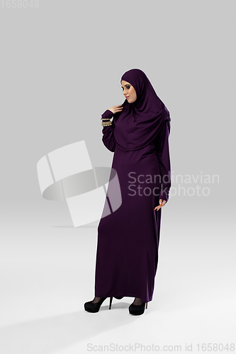 Image of Beautiful arab woman posing in stylish hijab isolated on studio background. Fashion concept