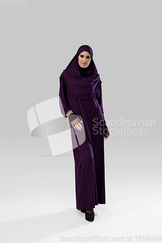 Image of Beautiful arab woman posing in stylish hijab isolated on studio background. Fashion concept