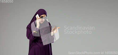 Image of Beautiful arab woman posing in stylish hijab isolated on studio background. Fashion concept