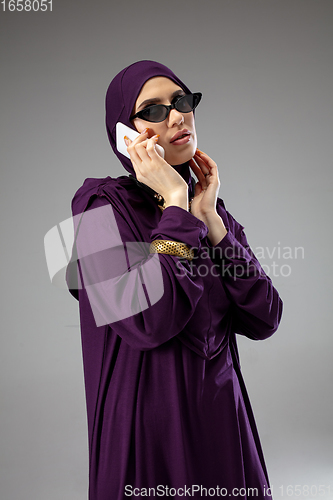 Image of Beautiful arab woman posing in stylish hijab isolated on studio background. Fashion concept