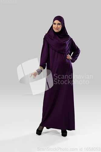 Image of Beautiful arab woman posing in stylish hijab isolated on studio background. Fashion concept
