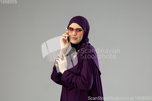 Image of Beautiful arab woman posing in stylish hijab isolated on studio background. Fashion concept