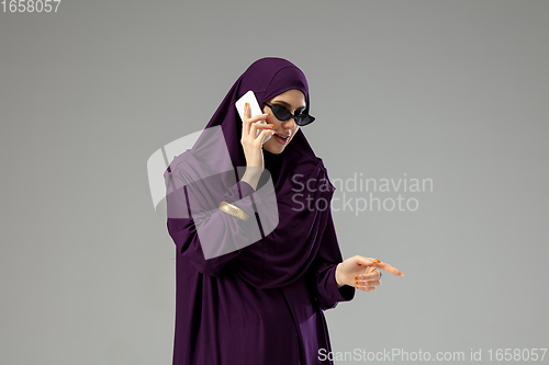 Image of Beautiful arab woman posing in stylish hijab isolated on studio background. Fashion concept