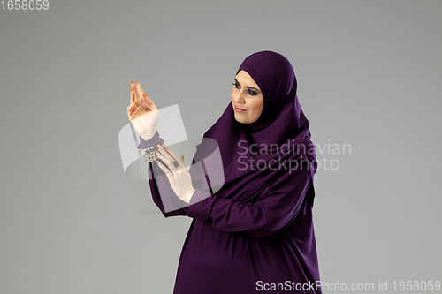 Image of Beautiful arab woman posing in stylish hijab isolated on studio background. Fashion concept