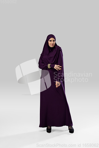Image of Beautiful arab woman posing in stylish hijab isolated on studio background. Fashion concept