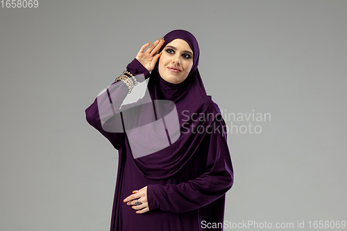 Image of Beautiful arab woman posing in stylish hijab isolated on studio background. Fashion concept