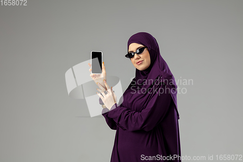 Image of Beautiful arab woman posing in stylish hijab isolated on studio background. Fashion concept