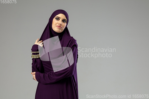 Image of Beautiful arab woman posing in stylish hijab isolated on studio background. Fashion concept