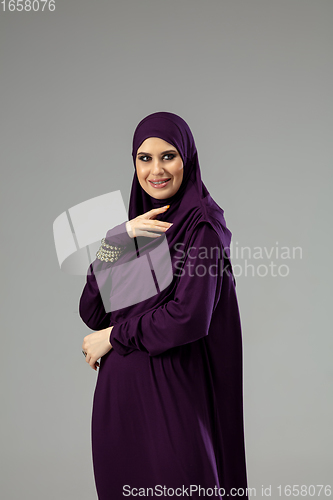 Image of Beautiful arab woman posing in stylish hijab isolated on studio background. Fashion concept