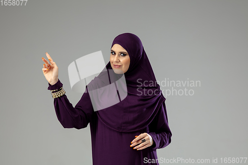 Image of Beautiful arab woman posing in stylish hijab isolated on studio background. Fashion concept