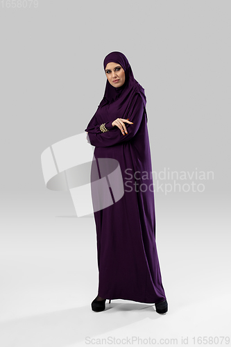 Image of Beautiful arab woman posing in stylish hijab isolated on studio background. Fashion concept