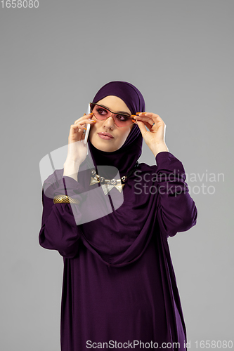 Image of Beautiful arab woman posing in stylish hijab isolated on studio background. Fashion concept