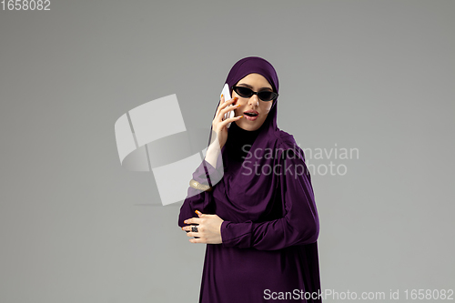 Image of Beautiful arab woman posing in stylish hijab isolated on studio background. Fashion concept