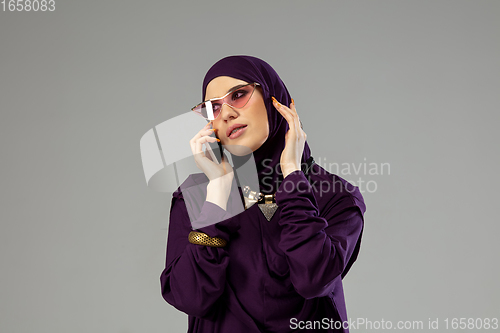 Image of Beautiful arab woman posing in stylish hijab isolated on studio background. Fashion concept