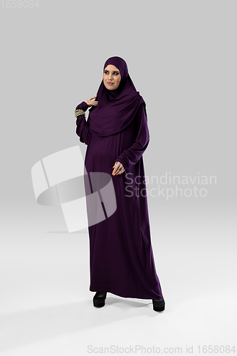 Image of Beautiful arab woman posing in stylish hijab isolated on studio background. Fashion concept