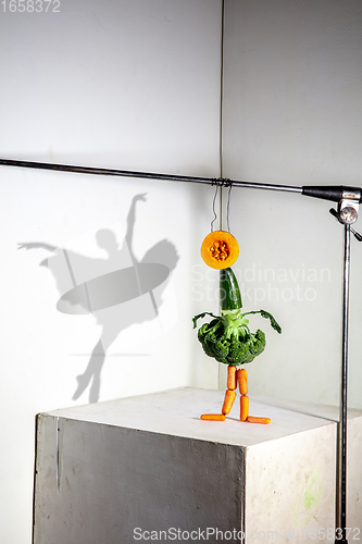 Image of Flying food composition making beautiful ballerina drawing shadow on the wall