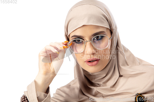 Image of Beautiful arab woman posing in stylish hijab isolated on studio background. Fashion concept