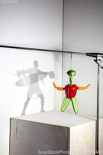 Image of Flying food composition making beautiful sportsman drawing shadow on the wall