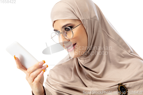 Image of Beautiful arab woman posing in stylish hijab isolated on studio background. Fashion concept