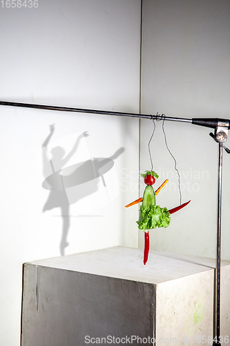 Image of Flying food composition making beautiful ballerina drawing shadow on the wall