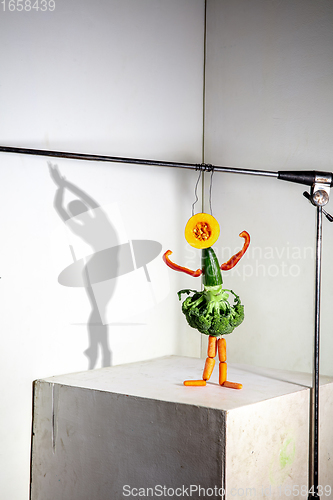 Image of Flying food composition making beautiful ballerina drawing shadow on the wall
