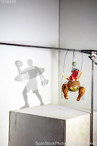 Image of Flying food composition making beautiful sportsman drawing shadow on the wall