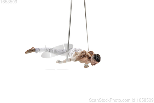 Image of Young male acrobat, circus athlete isolated on white studio background. Training perfect balanced in flight