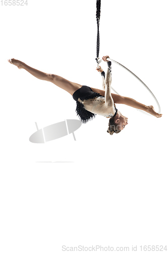 Image of Young female acrobat, circus athlete isolated on white studio background. Training perfect balanced in flight
