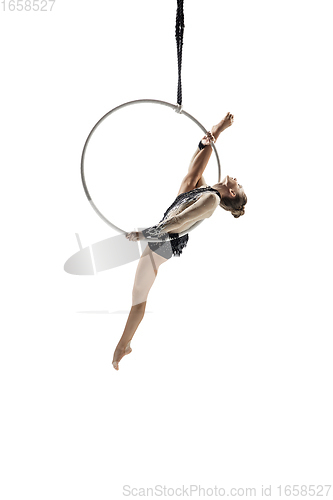 Image of Young female acrobat, circus athlete isolated on white studio background. Training perfect balanced in flight