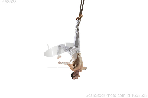 Image of Young male acrobat, circus athlete isolated on white studio background. Training perfect balanced in flight